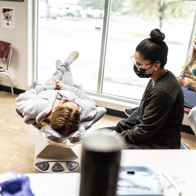 A team member at Hulme Orthodontics in San Antonio, TX discusses treatment with a patient.